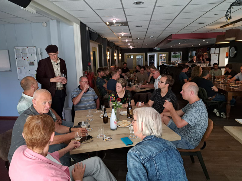 Vragen beantwoorden van geïnteresseerde gasten tijdens de bierproeverij in Grootebroek