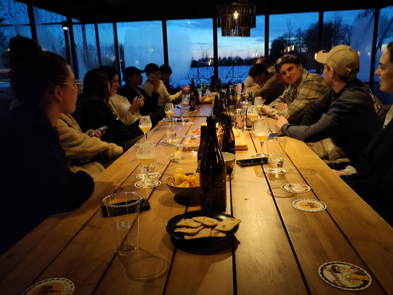 Een vriendengroep van 14 mensen heeft het gezellig tijdens een bierproeverij in West-Friesland, Noord-Holland
